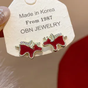 Close-up detail of red enamel horse stud earrings with sparkling crystals