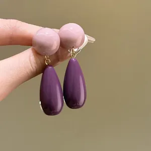 Detailed macro view of vintage-style acrylic earrings with pink and purple drops