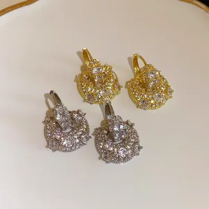 Macro view of gold and silver plated U-shaped hoop earrings with sparkling cubic zirconia.