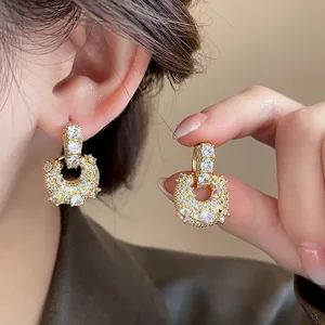 Close-up view of gold plated CZ U-shaped earrings showing sparkling pave details.