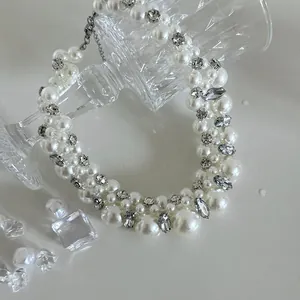 Close-up of elegant French style necklace featuring multi-sized pearls and crystals.