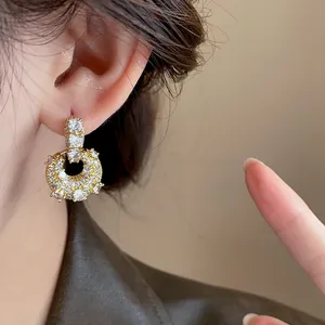 Detailed view of elegant gold-plated cubic zirconia U-shaped hoop earrings on a model
