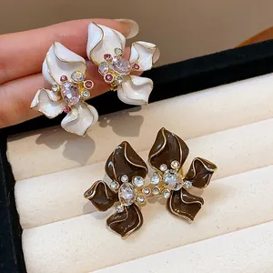 Close-up of retro Maillard flower stud earrings with rhinestones and enamel petals