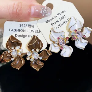 Close-up of vintage enamel flower stud earrings with sparkling crystal centers