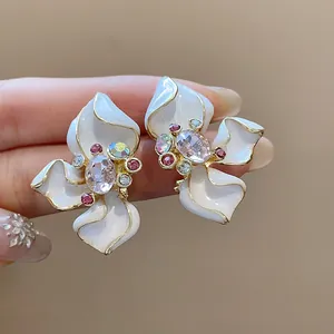 Macro view of elegant flower-shaped earrings with crystal inlay and enamel petals