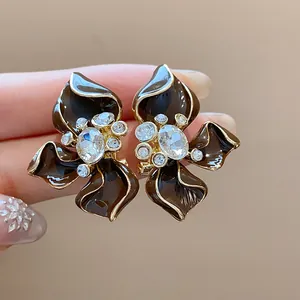 Detailed view of vintage brown enamel flower earrings with crystal centerpieces