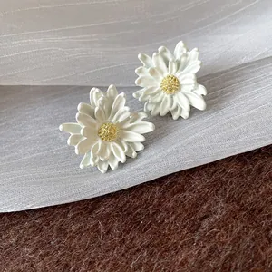 Detail showing elegant white daisy flower earrings with textured yellow centers for women