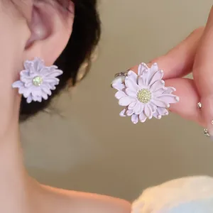Detailed macro view of lavender flower stud earrings with refined yellow textured centers