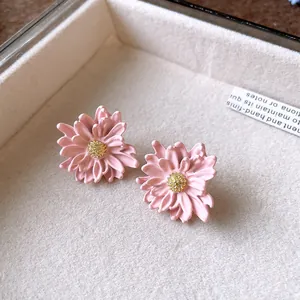 Exquisite close-up of pink flower stud earrings with yellow stamen in a jewelry box