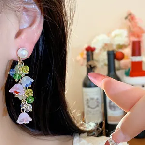 Detailed view of floral tassel pearl earrings with colorful resin flowers and beads.