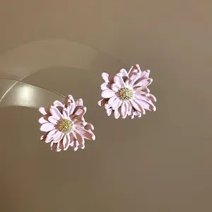 Detailed close-up of elegant pink flower stud earrings featuring sparkly gold centers