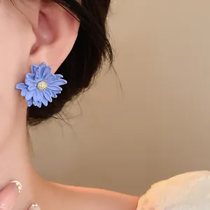 Detailed close-up showing a delicate blue lavender flower stud earring worn on an ear