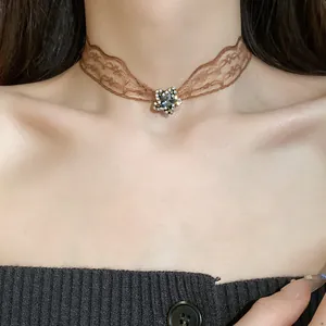 Close-up of a vintage lace choker featuring a sparkling rhinestone star pendant.