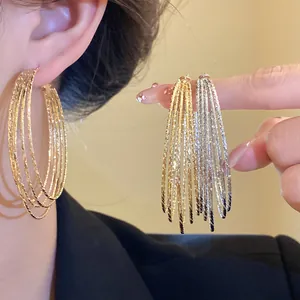 Detailaufnahme von mehrlagigen goldenen und silbernen Creolen mit strukturierter Oberfläche
