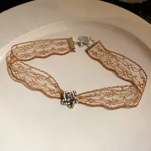 Detail of brown lace choker with star rhinestone pendant on white ceramic plate
