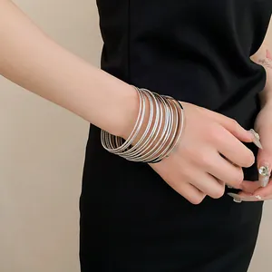 Close-up of multilayer silver metal bangles on wrist for a minimalist look