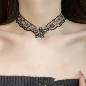 Close-up detail of black lace choker necklace with rhinestone-studded star pendant