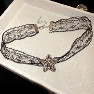 Close-up of elegant black lace choker featuring a sparkling rhinestone star pendant.