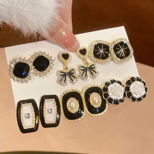 Detailed macro shot of French vintage earring set with pearls and black enamel flowers
