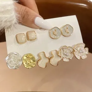 Close-up of elegant French-style flower and pearl gold-plated stud earring set