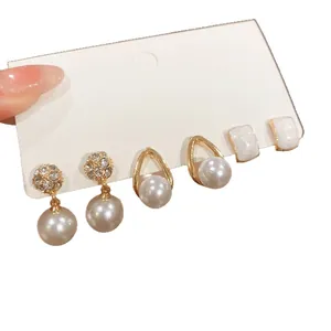 Elegant set of three pairs of pearl and rhinestone earrings with gold-toned finish