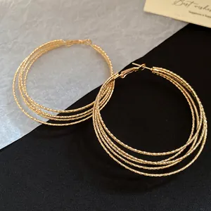 Detailansicht goldener mehrlagiger Creolen im Vintage-Stil mit strukturierter Oberfläche
