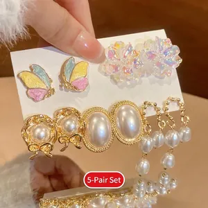 Detailed macro of the 5-pair butterfly and pearl earring set with silver needles