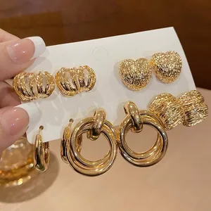 Close-up detail of a set of elegant golden earrings with various textured designs.