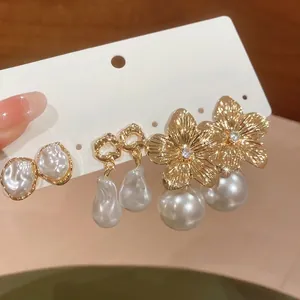 Close-up of elegant flower and pearl earring set on display card