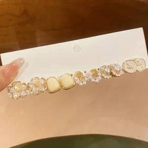 Close-up of 6 pairs French style floral and pearl enamel stud earrings on display card