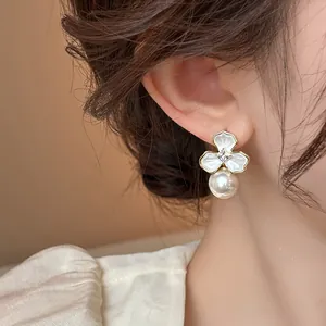 Close-up of elegant flower pearl earring with rhinestone detail on a model's ear