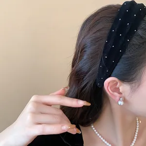 Detailansicht eines schwarzen Samt-Stirnbands mit eleganten weißen Tupfen am Modell