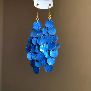 Vue détaillée des boucles d'oreilles pendantes en disques de coquillages bleus brillants