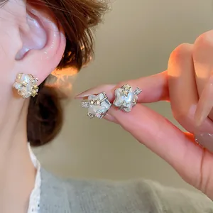 Detailed macro view of star-shaped earrings with pearl finish and zircon star accents.