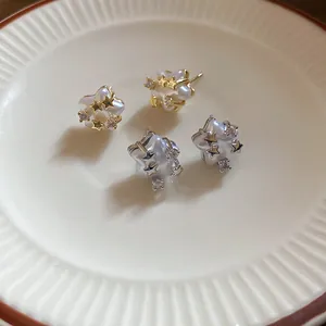 Detail view of elegant star stud earrings featuring lustrous pearls and shiny zircons
