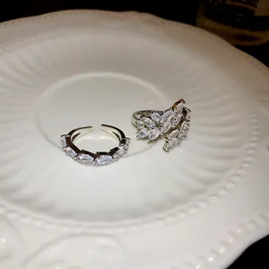 Vista macro dell'anello a foglia con zirconi incastonati su un elegante piatto di ceramica.