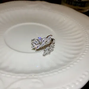 Dettaglio ravvicinato di un anello aperto a forma di foglia con zirconi molto brillanti