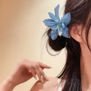 Barrette à cheveux élégante en forme de lys bleu sur cheveux brun foncé vue