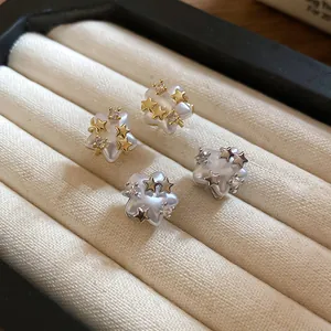 Close-up detail of elegant star-shaped pearl earrings with sparkling zirconia accents