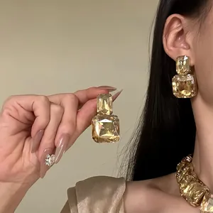 Macro view of luxurious champagne square crystal stud earrings and matching statement necklace