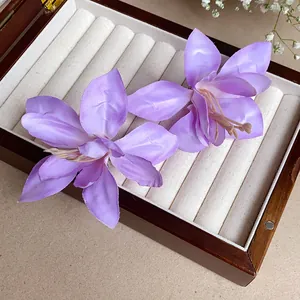 Vue détaillée de deux pinces à cheveux en tissu lys violet dans une boîte à bijoux.
