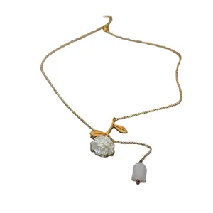 Collier vintage français élégant avec pendentif rose blanche et pompon doré délicat.