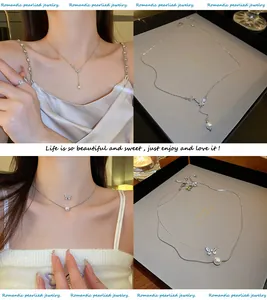 Détail d'un collier papillon de style français avec pampille en perle, fini argenté.