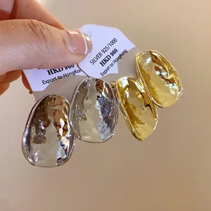 Detailansicht der stilvollen, gehämmerten geometrischen Metallstecker in Gold und Silber