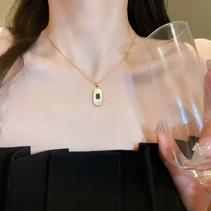 Elegant close-up of a titanium steel necklace with emerald green zircon pendant on a model