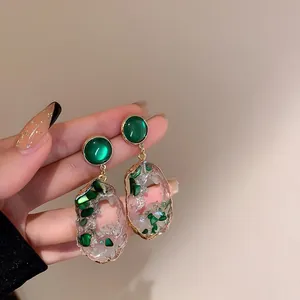 Detailed view of retro emerald green geometric drop earrings with gold-toned finish