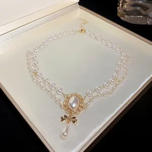 Detailansicht der Vintage Perlenkette mit goldener Schleife und Tropfenperlenanhänger