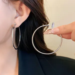 Detail of large silver minimalist hoop clip-on earrings showing comfortable mosquito coil clip