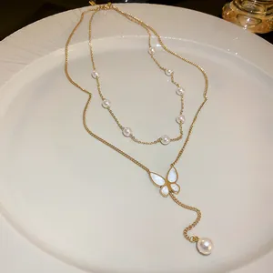 Detailed view of an elegant gold-toned double-layered necklace with butterfly and pearls
