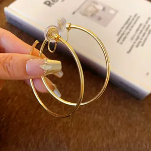 Detail of gold-tone hoop clip-on earrings for non-pierced ears with mosquito coil clip.